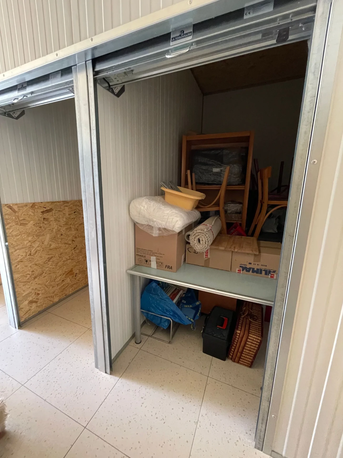 Box intérieur occupé par des cartons et du mobilier